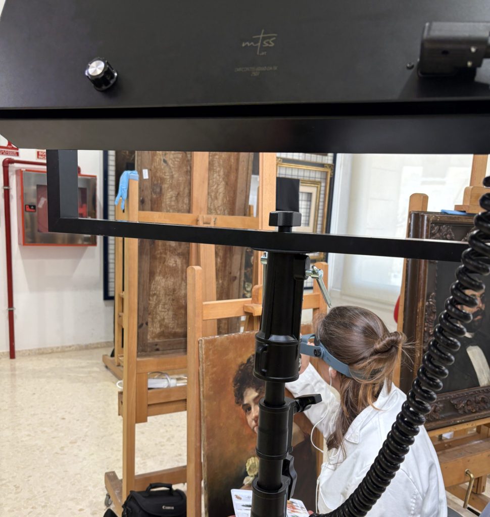 Técnico del departamento de restauración del Museo de Bellas Artes de València interviniendo una obra a la luz de una de nuestras luminarias.